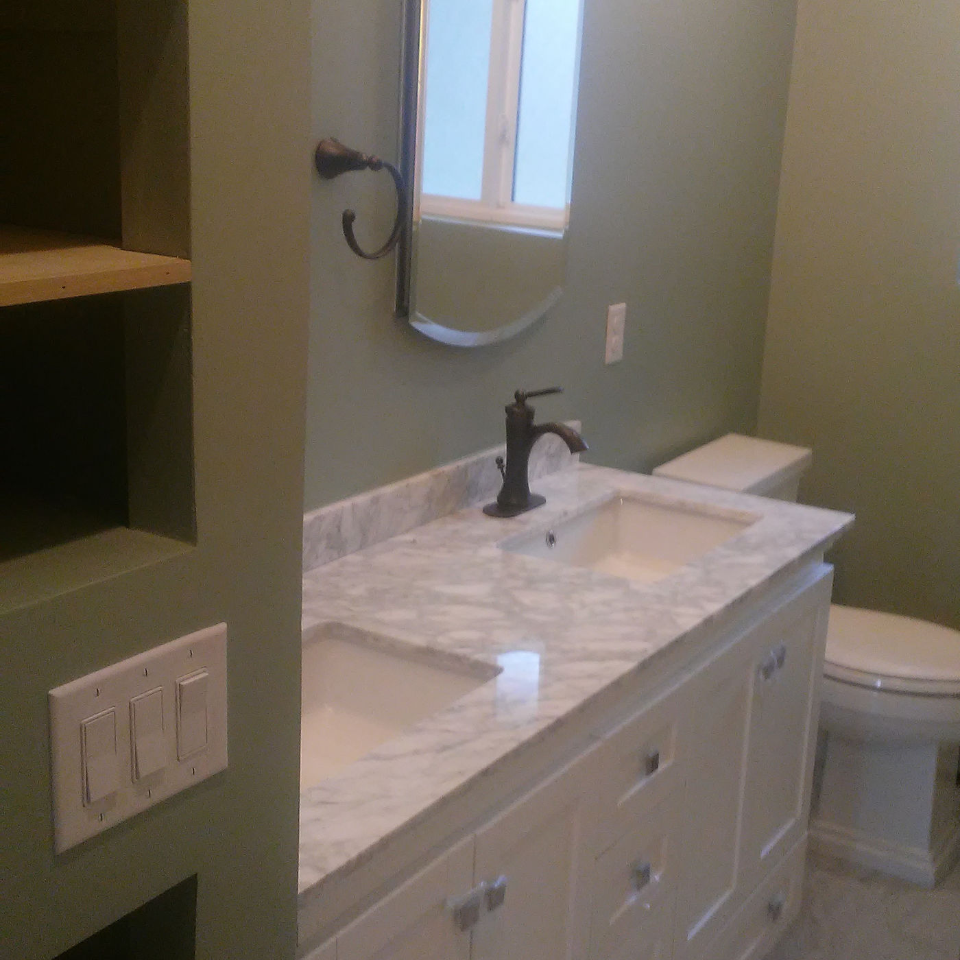 Finished bathroom with a white double vanity and sage walls